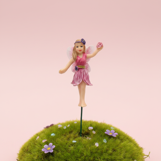 Pink dancing fairy garden stake figurine in a fairy garden setting
