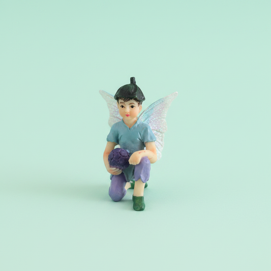 Fairy boy playing soccer miniature figurine on mint green background